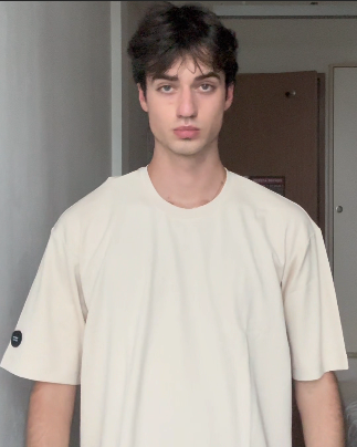 Person wearing a plain beige t-shirt in an indoor setting